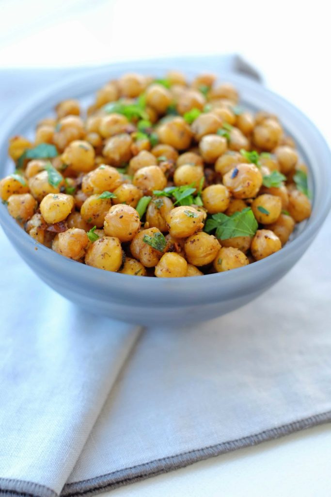 A light blue bowl filled with roasted chickpeas sitting on a folded napkin