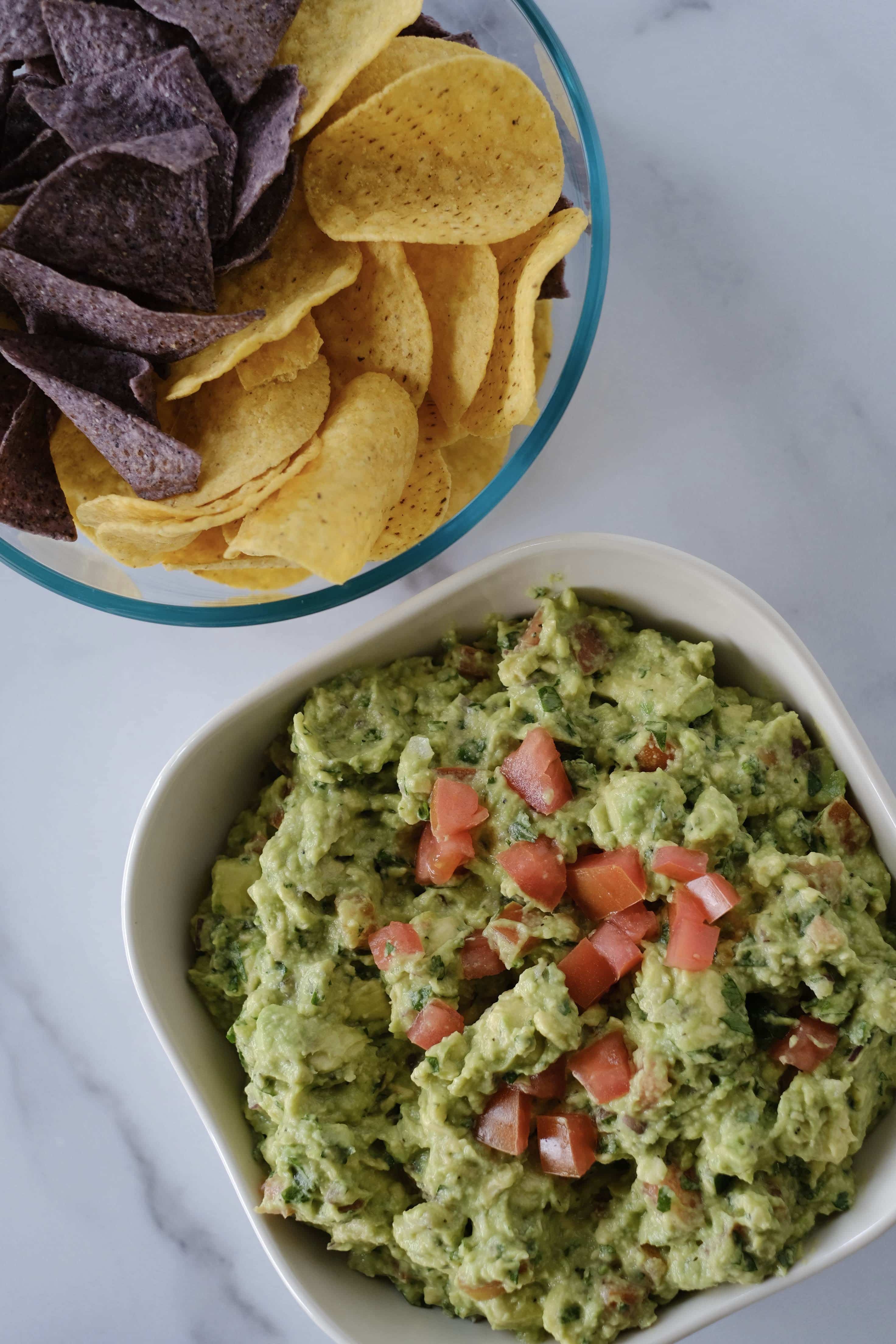 Guacamole and chips on a white table